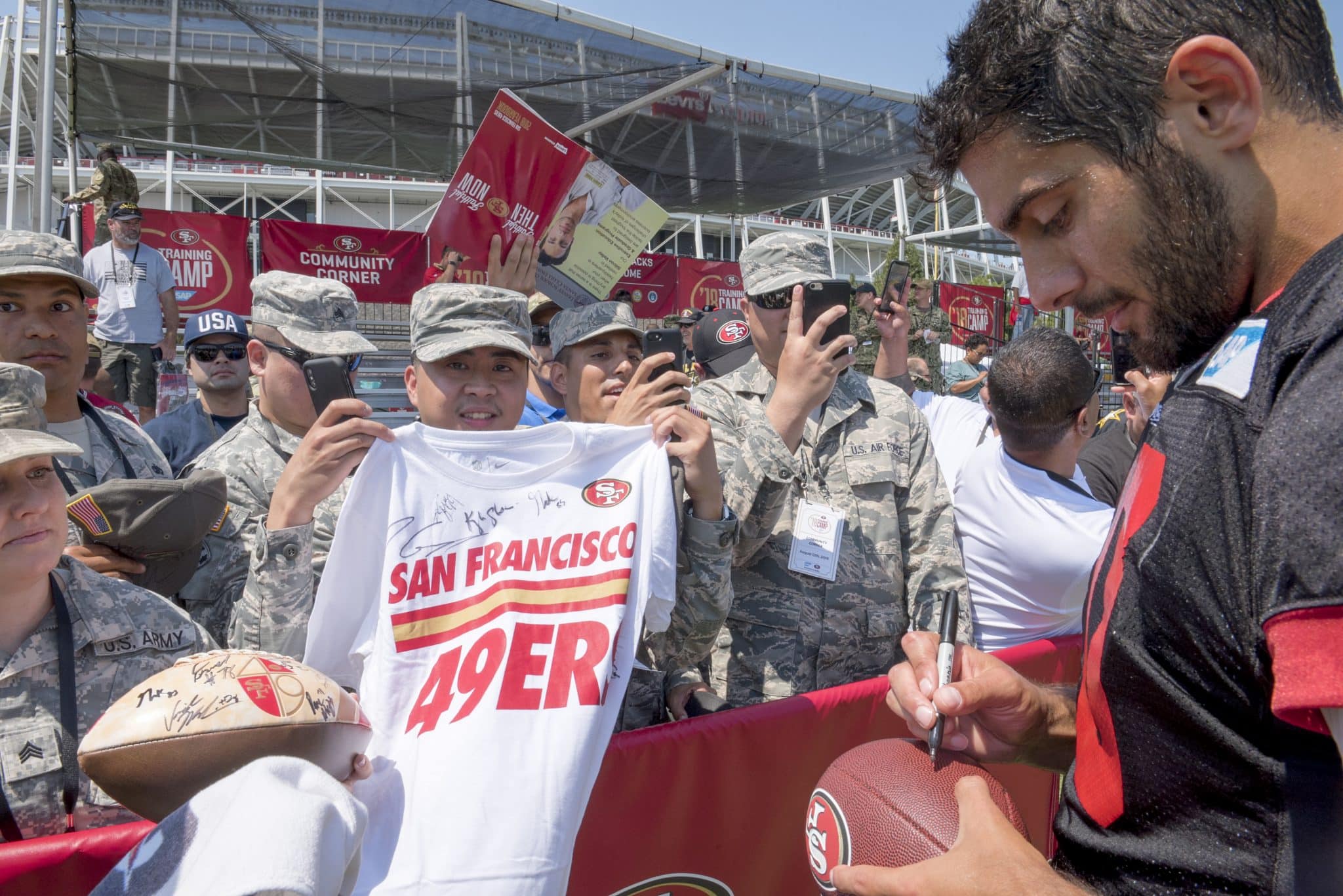Jimmy Garoppolo, a 49ers quarterback, signs a football for a fan at the SAP Performance Facility, Santa Clara, Calif., Aug. 12, 2018. The 49ers organization invited military members from the local area to observe their training camp during a military appreciation day. (U.S. Air Force photo by Lan Kim)