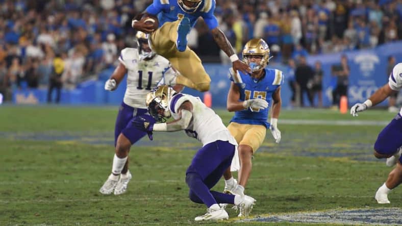 UCLA Bruins Stage Just Right for Utah Utes Act 2 UCLA Quarterback Dorian Thompson-Robinson Hurdles Washington Huskies Defender. Photo Credit: Greg Turk | UCLA Athletics